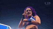 a woman with purple hair is wearing a blue and purple outfit ..