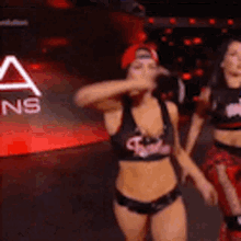 two women are dancing on a stage in front of a sign that says a ns .
