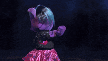 a purple teddy bear is holding a microphone and pointing at the camera