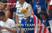 a man wearing a bald eagle mask says romain team usa 2028 olympics in the crowd