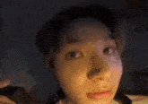 a close up of a person 's face with a phone in their hand and looking at the camera .
