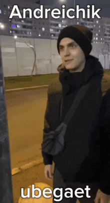 a man wearing a black beanie and a black jacket with the name andreichik ubebaet written on the bottom