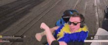 a man wearing sunglasses and a feather boa is playing a video game with a score of 30