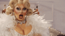 a drag queen is wearing a feather boa and a necklace