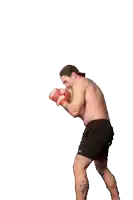 a shirtless man wearing boxing gloves is dancing