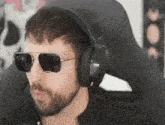 a man with a beard wearing sunglasses and headphones .
