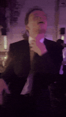 a man in a suit and tie is dancing in a room
