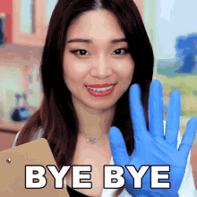 a woman wearing blue gloves holds a clipboard with the words bye bye on it