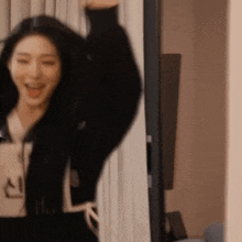 a woman is standing in front of a mirror with her hands in the air .
