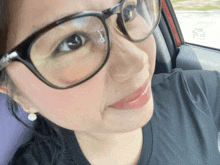 a close up of a woman wearing glasses with a toyota sticker on the windshield