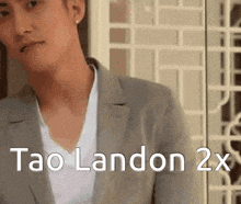 a man in a suit and a white shirt with the words tao landon 2x