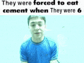 a man in a blue shirt is being forced to eat cement