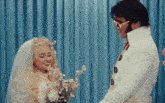 a man dressed as elvis stands next to a woman in a wedding dress