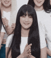 a woman with long black hair is smiling and clapping