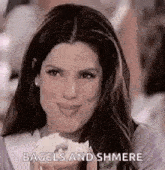 a woman is holding a bagel in her hand and smiling at the camera .
