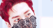 a man with red hair and a black lace mask on his face