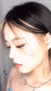 a close up of a woman 's face with a necklace