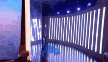 a man is standing in front of a wall with a lot of lights on it