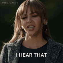 a woman says i hear that while wearing a gray coat