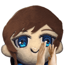 a stuffed doll with brown hair and blue eyes has two hands on its face