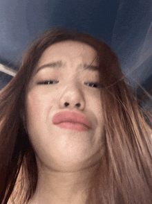 a close up of a woman 's face with her hair blowing in the wind