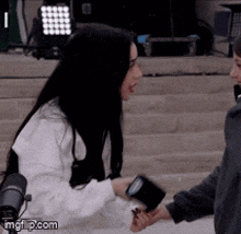 a woman in a white sweater is talking to a man in a gray sweater