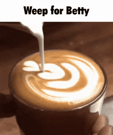 a person is pouring milk into a cup of coffee with the caption weep for betty .