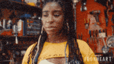 a woman wearing a yellow shirt that says ironheart on it