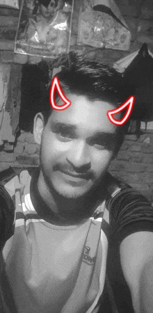 a man with devil horns on his face is smiling for the camera