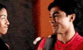 a man in a red shirt is looking at a woman