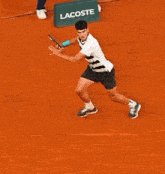 a man in a striped shirt is holding a tennis racket on a tennis court