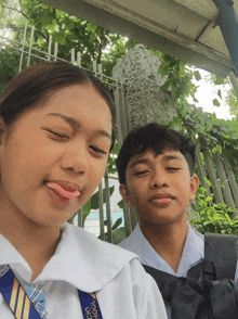 a boy and a girl are posing for a picture and the girl is wearing a lanyard that says uic school