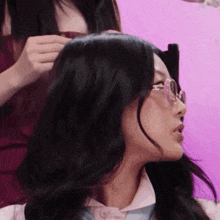 a woman wearing glasses is being touched by another woman