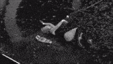 a black and white photo of two women wrestling with a belt on the ground