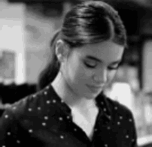 a black and white photo of a woman wearing a black shirt with white polka dots .