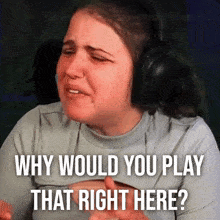 a woman wearing headphones is crying and asking why would you play that right here