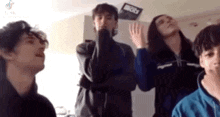 a group of young people are standing in a room with their arms crossed .