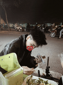 a man with a smiley face on his face is looking at his phone