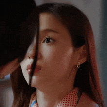 a close up of a woman 's face with a man covering her mouth