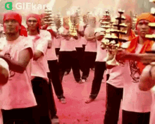 a group of men are standing in a line holding candles and playing instruments .