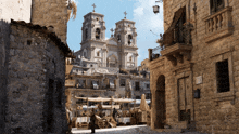 a church with a cross on top of it is surrounded by a narrow street