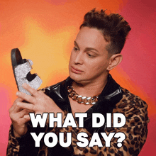 a man in a leopard print jacket is holding a pair of sandals and says what did you say