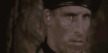 a man with a lot of mud on his face is looking at the camera .