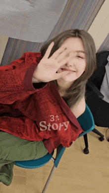 a woman wearing a red shirt that says story covering her face