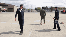 three men in military uniforms are walking on the runway