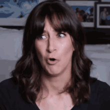a woman with a surprised look on her face is making a funny face .