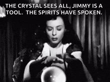 a black and white photo of a woman holding a crystal ball