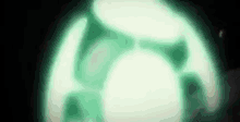 a green light is shining in the dark and looks like a soccer ball .