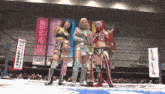 three female wrestlers stand in a ring with a neo genesis banner behind them