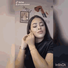 a woman adjusts her earring in a video that is titled tiktok